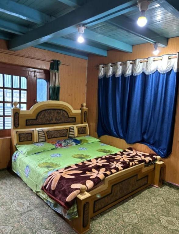 a bedroom with a large bed with blue curtains at A Sappers Dream House Markoot Gurez in Gurais
