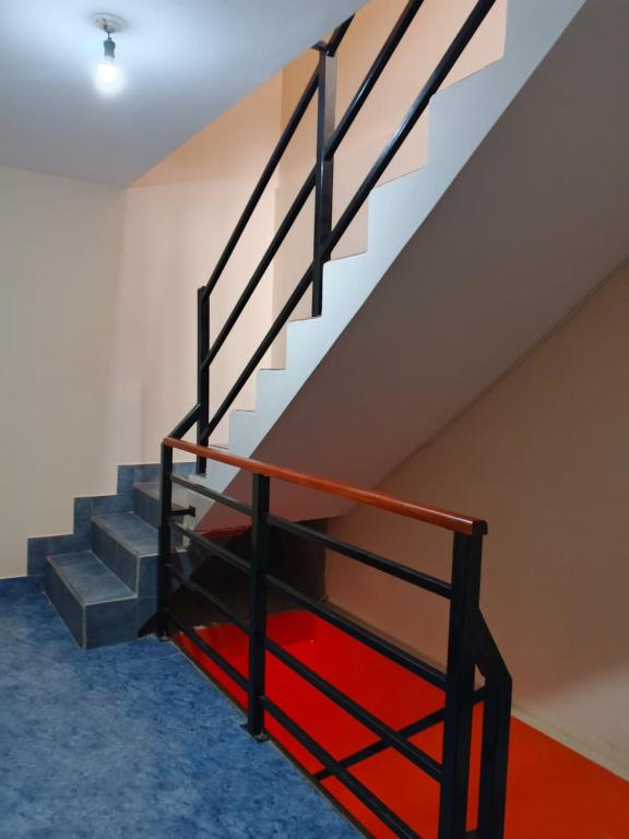 a staircase in a room with blue carpet at El Refugio de Anita in Iruya