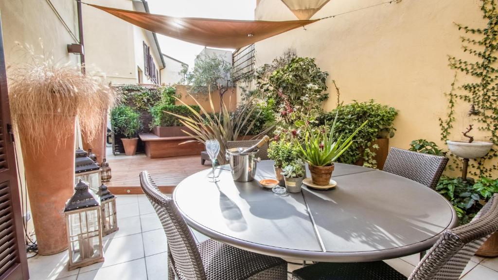 a table and chairs on a patio with plants at B&B Guerrazzi in Pisa