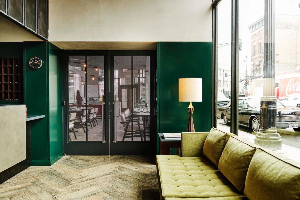 a living room with a couch and a green wall at The Robey, Chicago, a Member of Design Hotels in Chicago