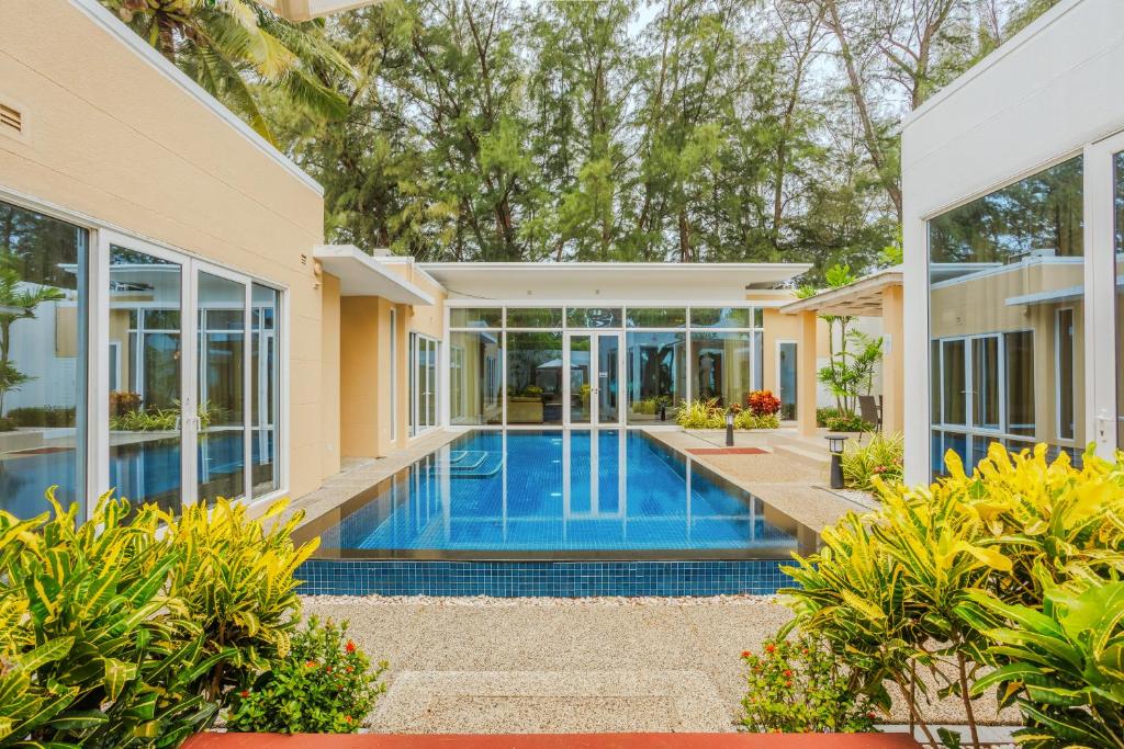 an exterior view of a house with a swimming pool at Andaman Pool Villas, Maikhao Beach Phuket in Mai Khao Beach