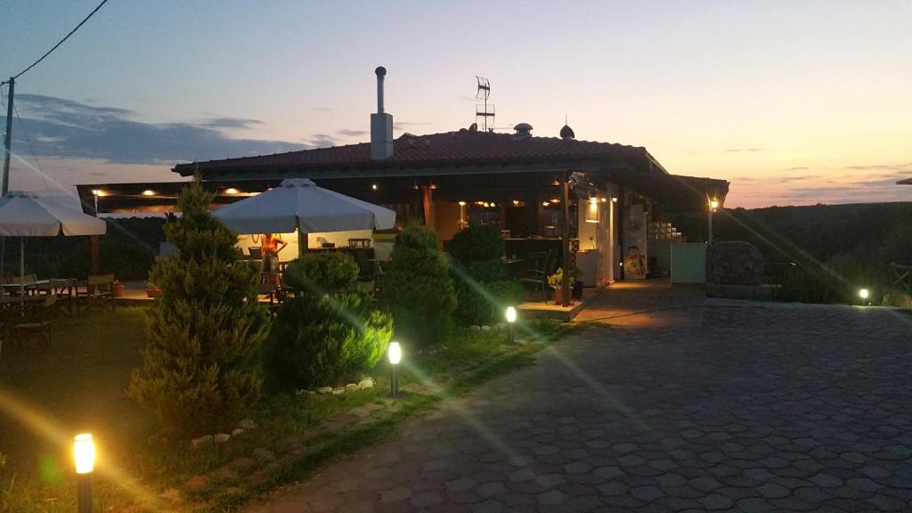 un edificio con patio e ombrelloni di notte di Athos Bay Villa ad Ammouliani