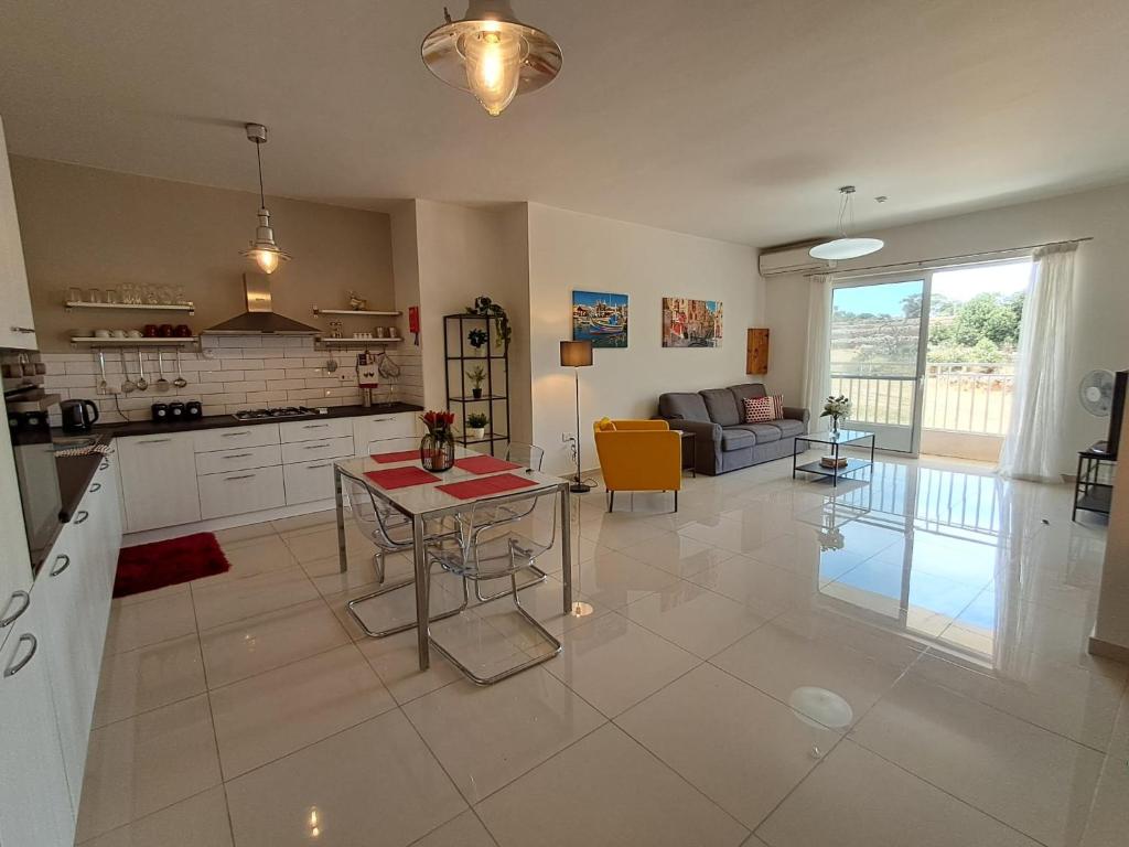 a kitchen and living room with a table and a couch at Lanyard Hitch Court in Marsaxlokk