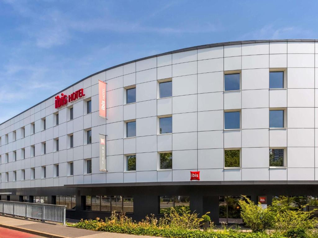 a large white building with a sign on it at ibis Genève Petit Lancy in Geneva