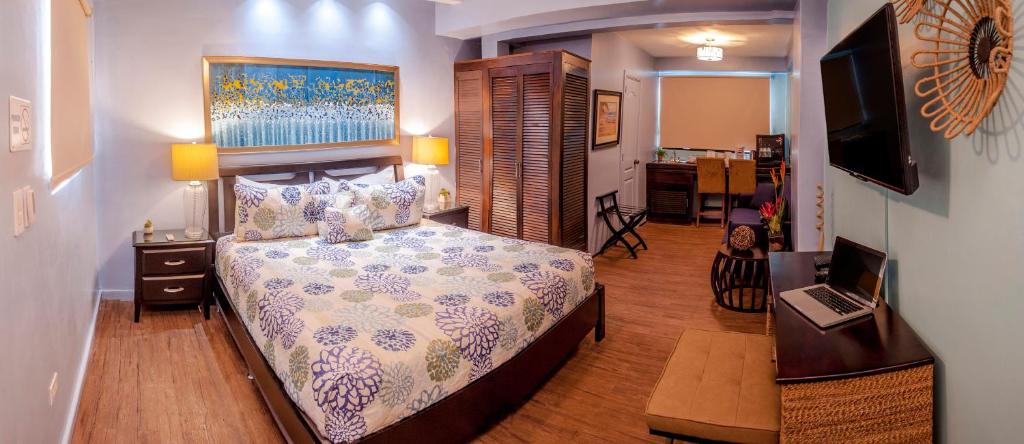 a bedroom with a bed and a desk with a laptop at Magnolia Inn in Panama City