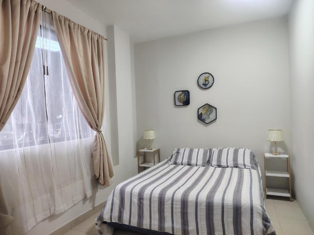 a bedroom with a bed and a window at Minidepartamento Independiente in San José de Chaltura