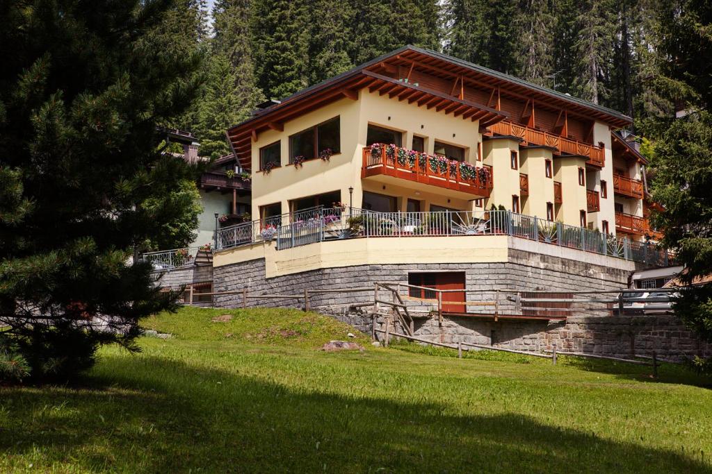 a building with a balcony on top of a hill at Hotel Erika in Madonna di Campiglio