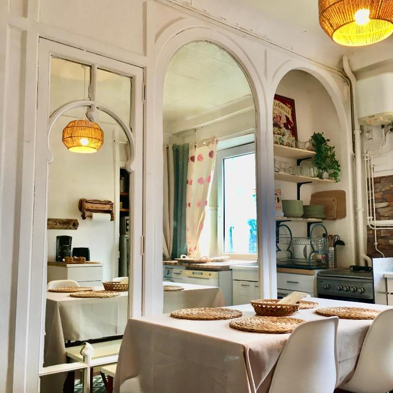 a kitchen with a table with chairs and a mirror at T2 Hyper centre le mont dore face thermes et cure in Le Mont-Dore