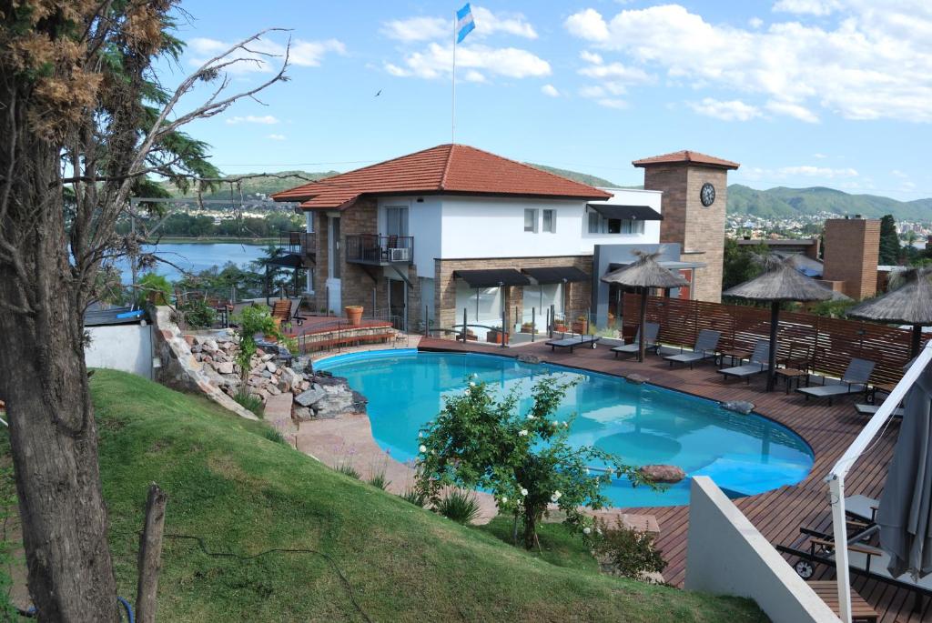 a large swimming pool in front of a house at Tagore Suites Hotel in Villa Carlos Paz