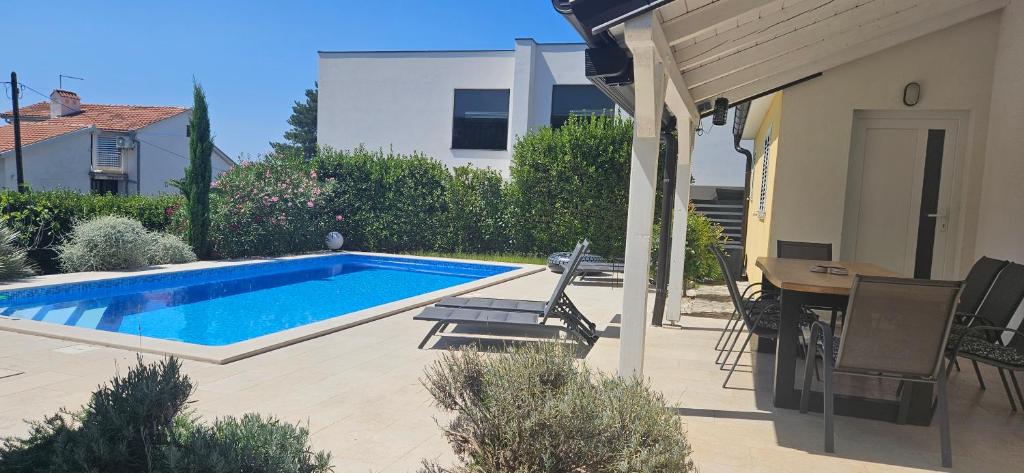 a swimming pool sitting next to a house at Apartment with private pool in Njivice
