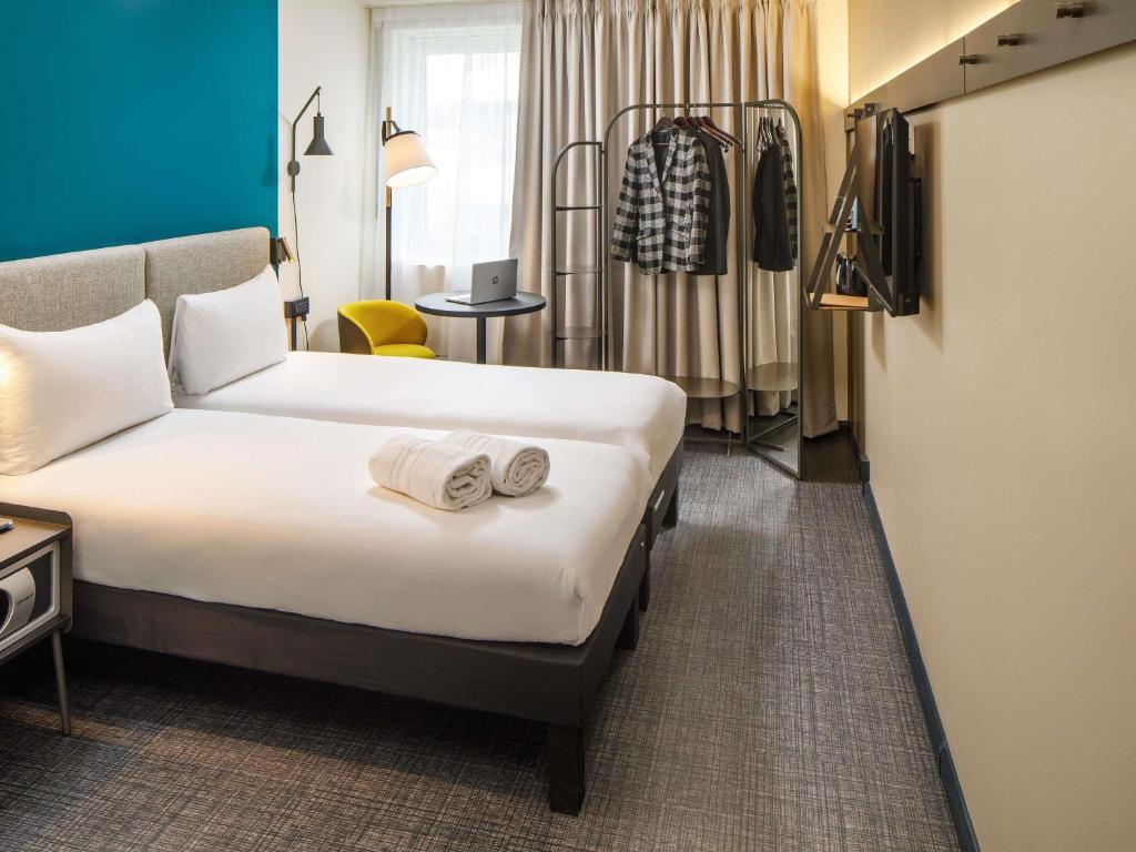 Twin guest bedroom with yellow chair at ibis London Blackfriars