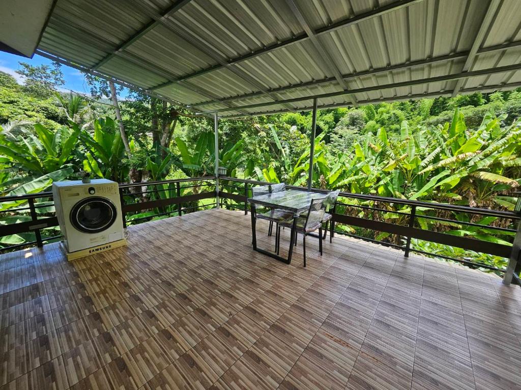 a patio with a table and a speaker on a deck at Rim Tarn Phu View Chiang Mai in Ban Khanin Tai