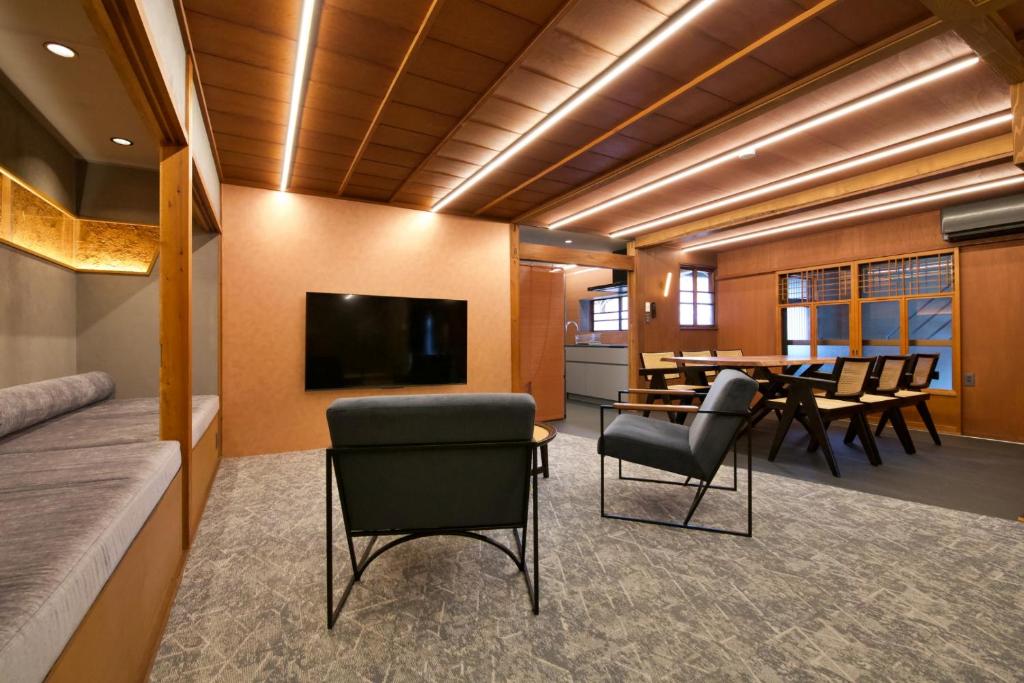 a conference room with a table and chairs and a television at 樂 Gou in Ise
