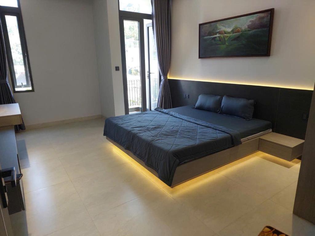 a bedroom with a bed with a light on the floor at Maison Art in Quy Nhon