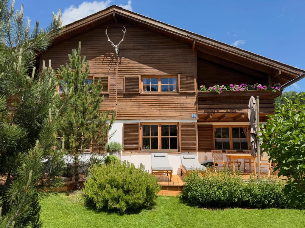 a log house with a patio and lawn at Chalet Tirolia in Kirchdorf in Tirol