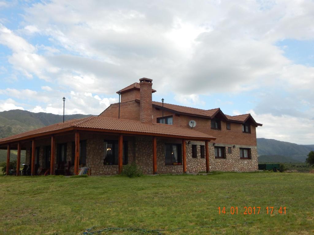 a brick house in a field with mountains in the background at La Palmita in Papagayos