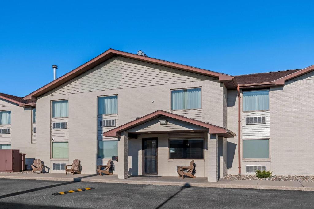 a rendering of a building with benches in front at Super 8 by Wyndham Perham in Perham