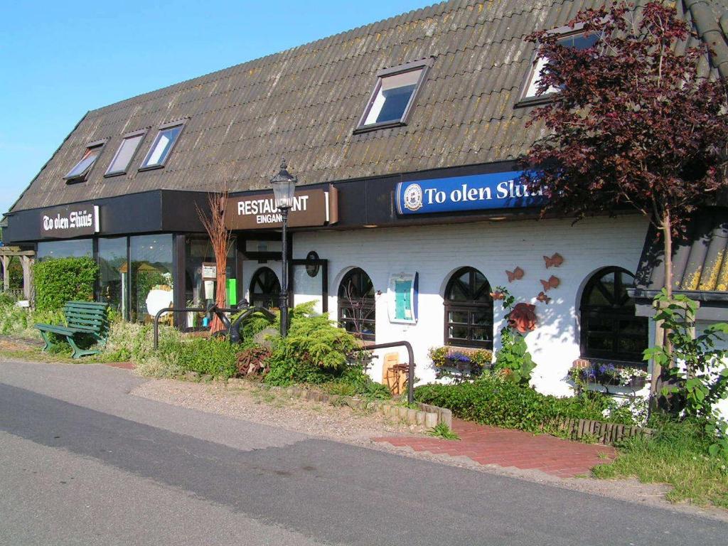 een gebouw met een bord waarop staat top open shop bij Pension To olen Slüüs Dagebüll in Dagebüll