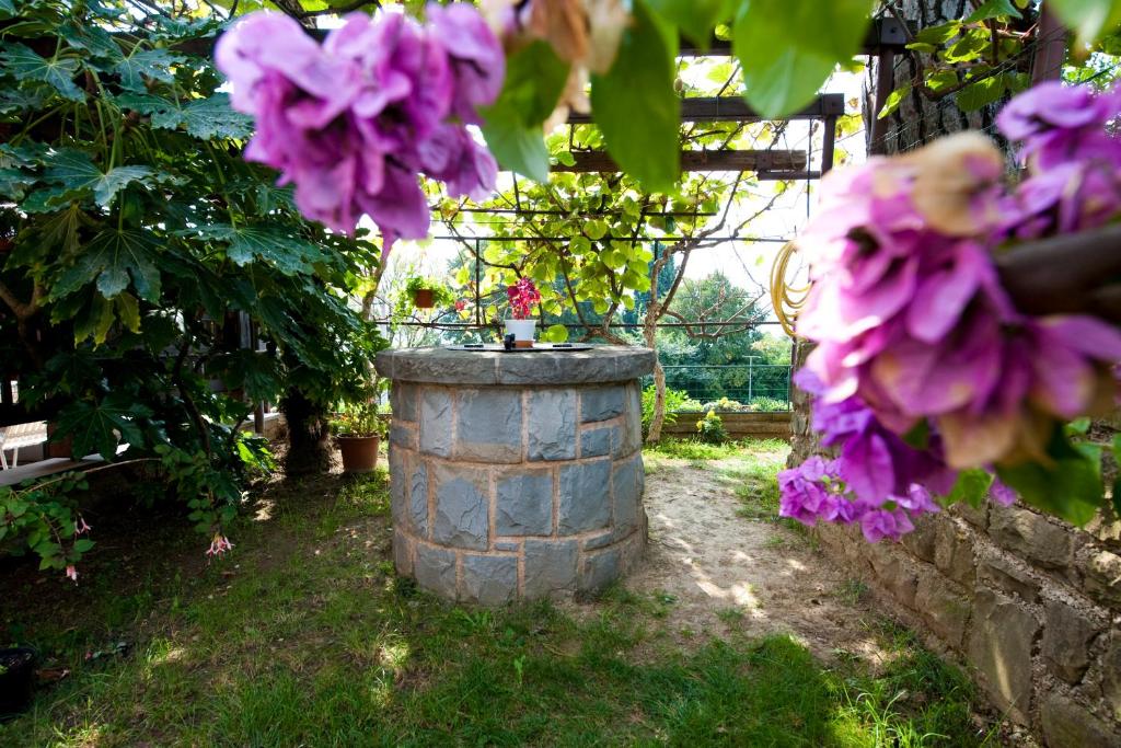 a stone barrel in a garden with purple flowers at Apartments Portoroz in Portorož