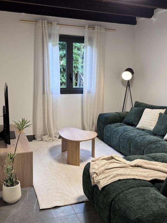 a living room with two green couches and a table at Villa Tchama in Salazie