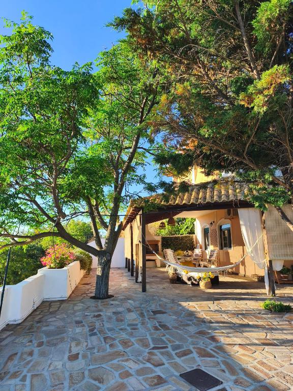 a building with a tree and a patio at Joanna Studio in Akamatra