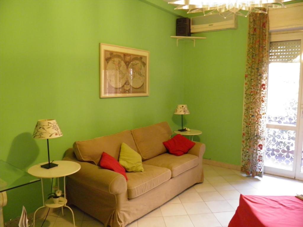 salon z kanapą i zieloną ścianą w obiekcie La Casa Dei Gerani w Rzymie