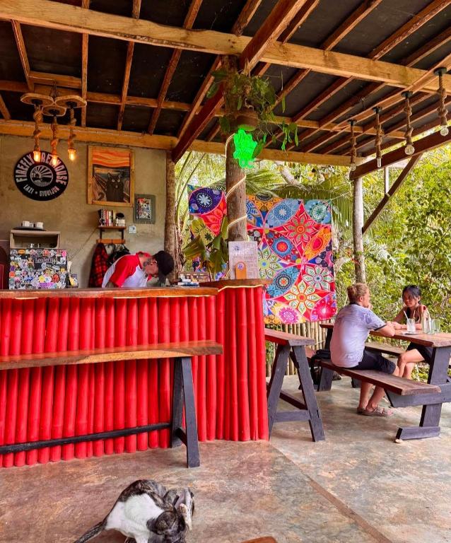 a group of people sitting at a bar in a restaurant at Firefly Treehouse Cafe and Bar in Ytaya