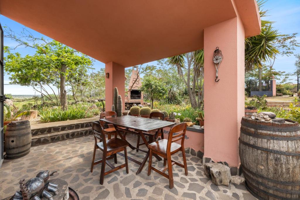 an outdoor patio with a wooden table and chairs at Villa Anna con giardino in Flussio