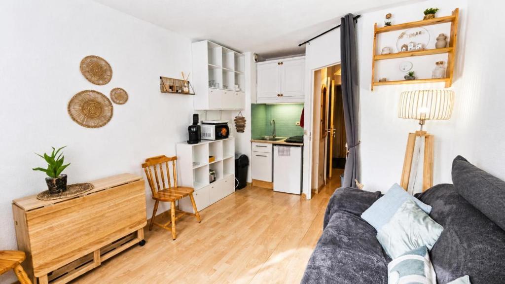a living room with a couch and a table at Cozy studio in La Foux
