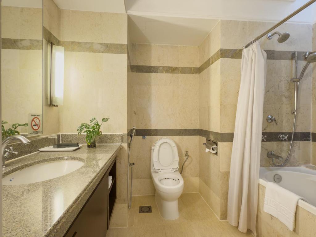 A marble-look bathroom with a bathtub, shower and bidet spray.