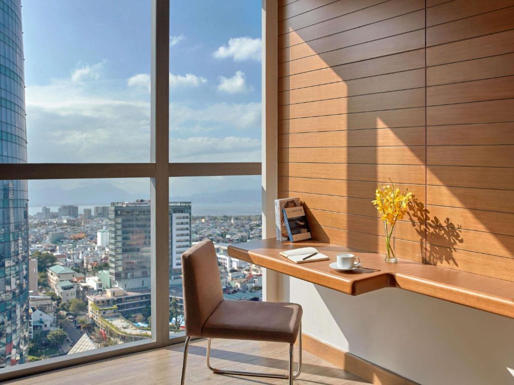 A compact built-in work desk beside floor-to-ceiling windows with a sweeping city view.