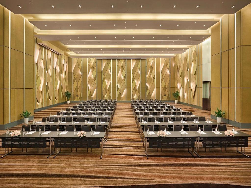 A large lecture room with classroom tables facing a presentation area.