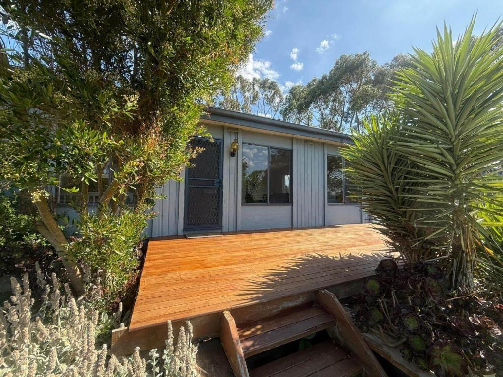 a house with a wooden deck in a garden at Prom Coast Residence in Fish Creek