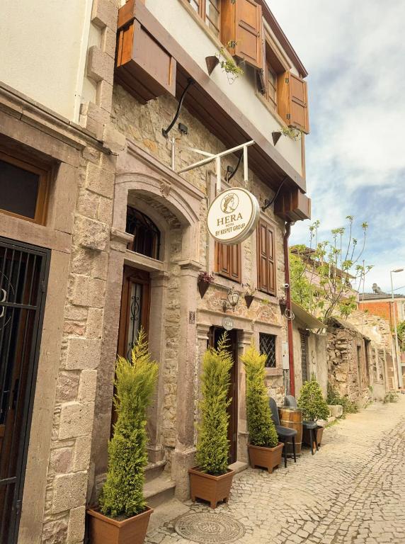 a building with a sign on the side of it at Hera Pansiyon in Ayvalık