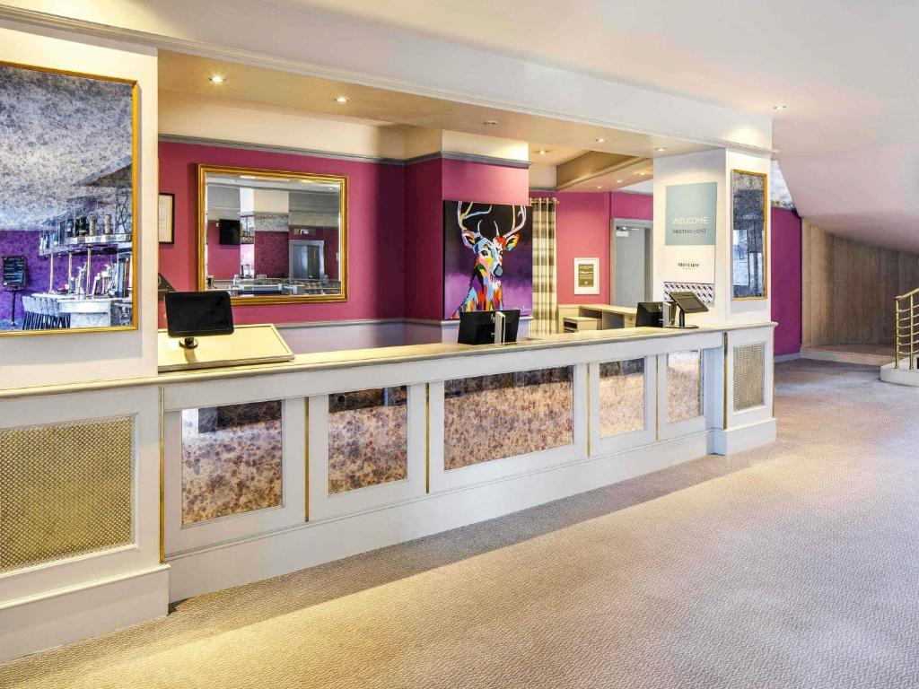 a lobby with a bar with purple walls at Mercure Ayr Hotel in Ayr