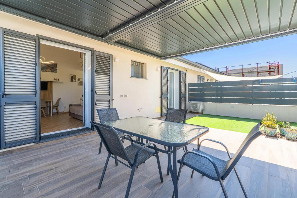 a patio with a table and chairs on a deck at Casa Mare Vecchio in Avola