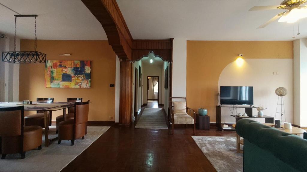 a living room with a table and a dining room at Boudha Breeze Suites 3bhk in Kathmandu