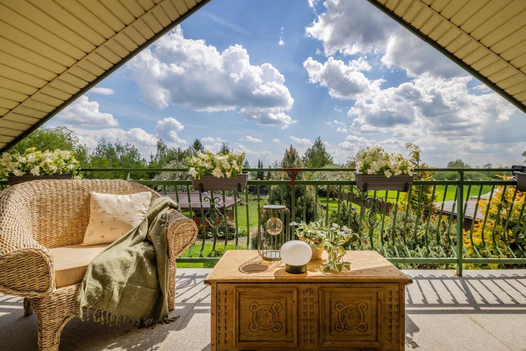 a patio with a chair and a table on a balcony at Dworek Biebrzański in Augustów