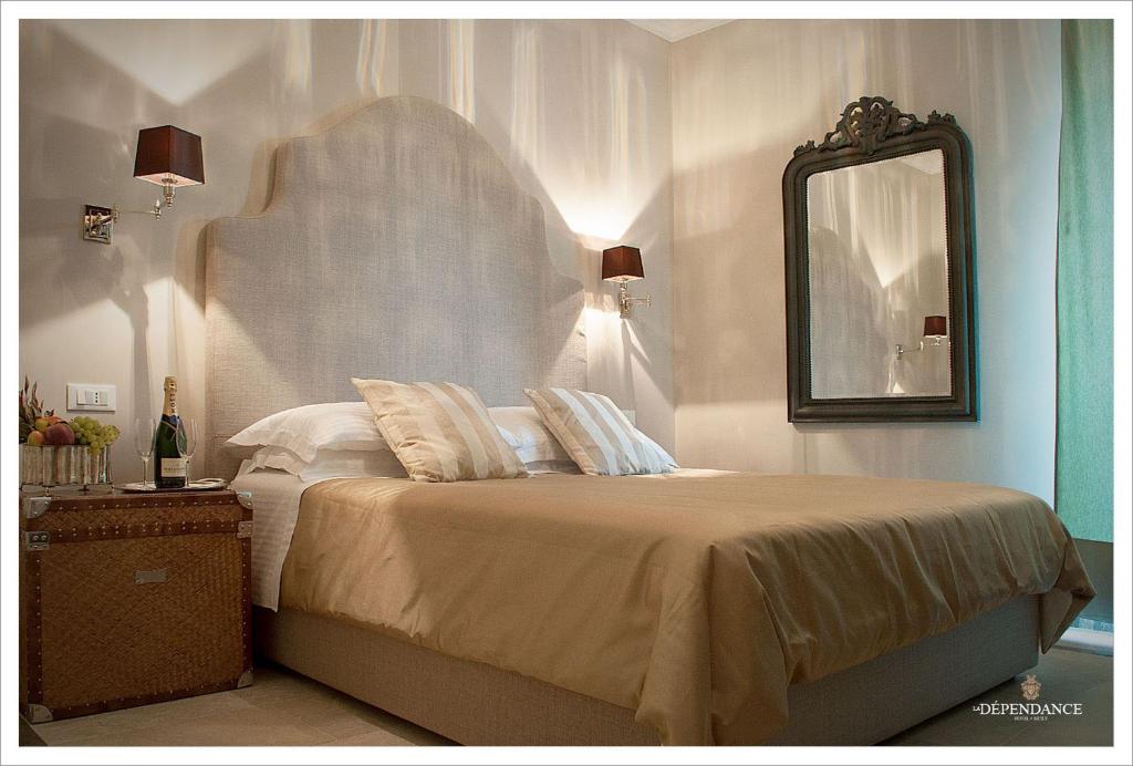 a bedroom with a large bed with a mirror at La Dépendance Hotel in Noto