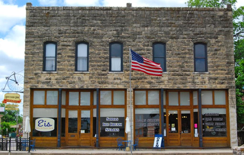 a brick building with an american flag on it at Upstairs Inn in Hico