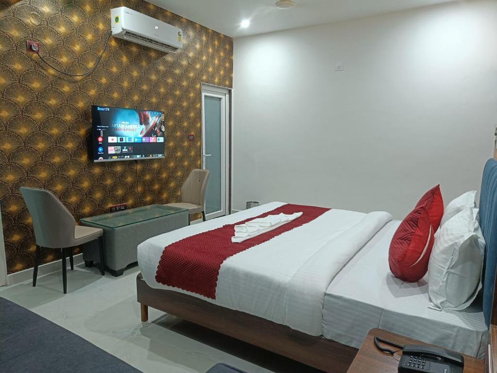 a bedroom with a bed and a tv on a wall at Hotel SS Residency in Patna