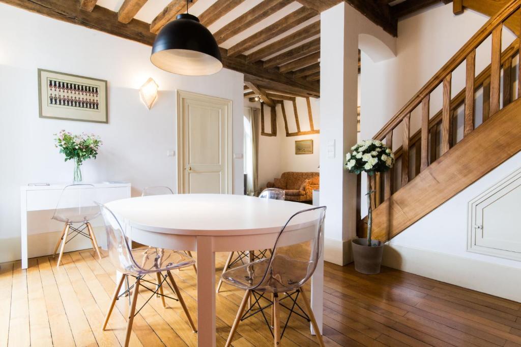 une salle à manger avec une table et des chaises blanches dans l'établissement Les Bons Enfants, à Dijon