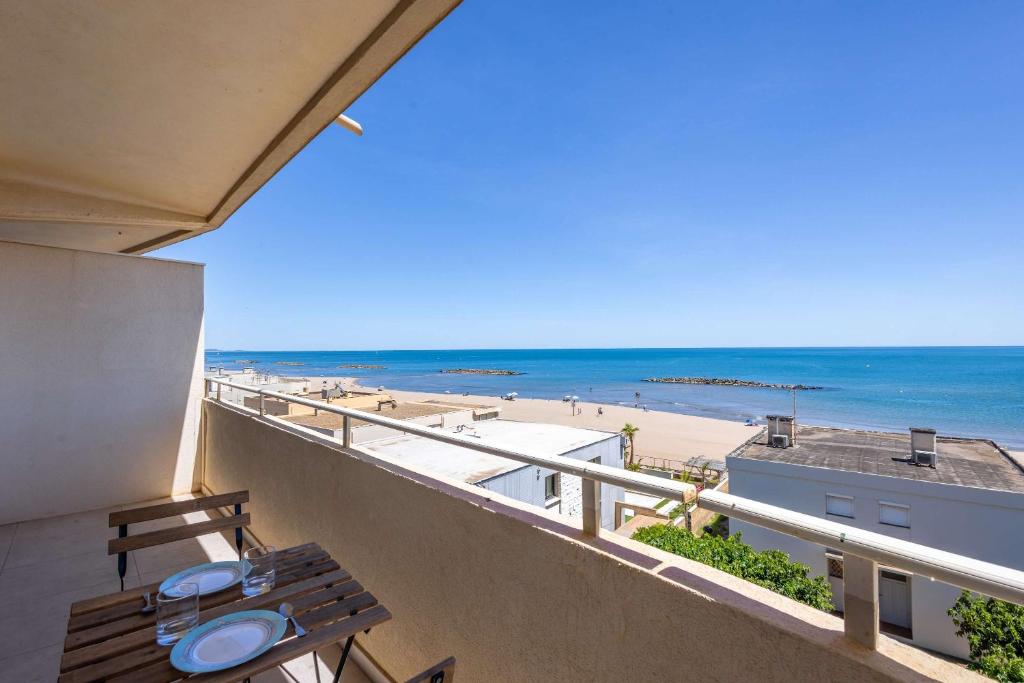 a balcony with a table and a view of the beach at Valras'Loc - Evasion Marine in Valras-Plage
