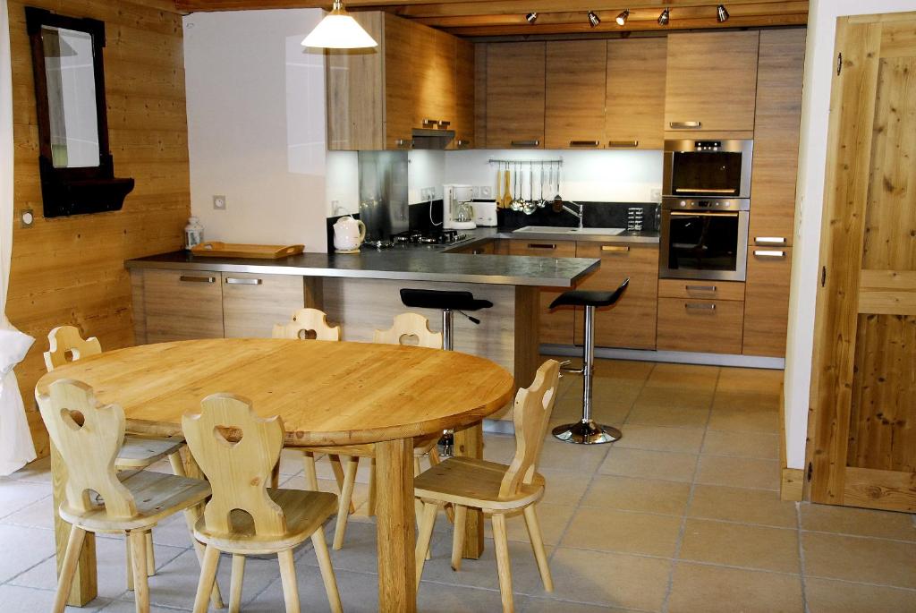 - une cuisine avec une table et des chaises en bois dans l'établissement Gîtes Les Pralets, à Saint-Eustache