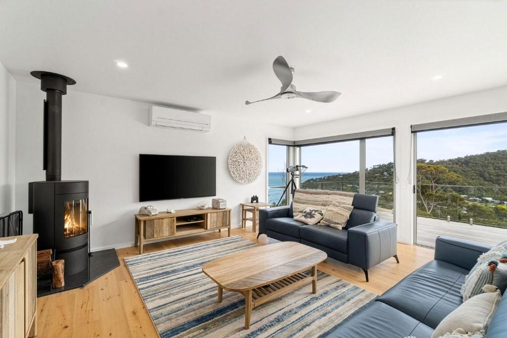 a living room with a blue couch and a fireplace at Gums & Ocean Hideaway at Wye in Wye River