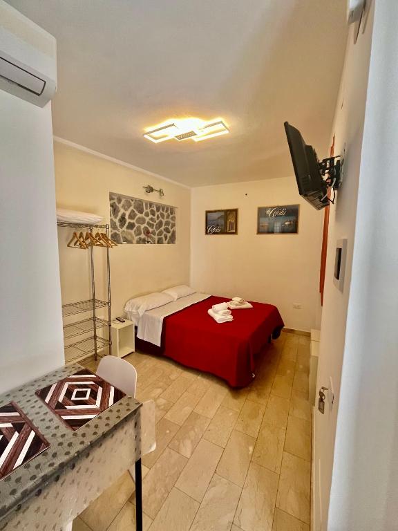 a bedroom with a bed with a red blanket at Studio Osnao Historic City Center in Cefalù