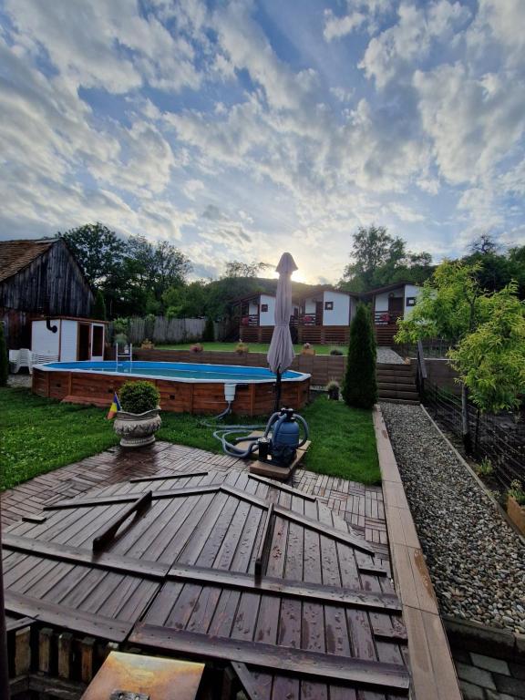a statue of a bird standing on a wooden deck near a pool at Flori Haus Saschiz in Saschiz