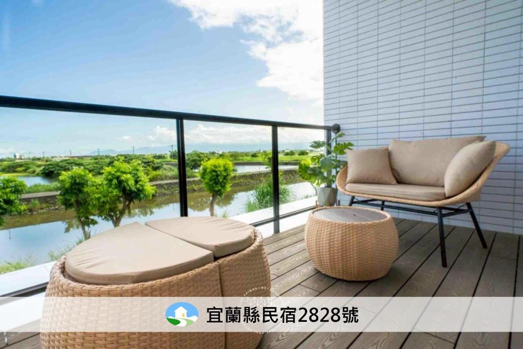 a balcony with a couch and a chair on a building at 岫湖居 in Jiaoxi