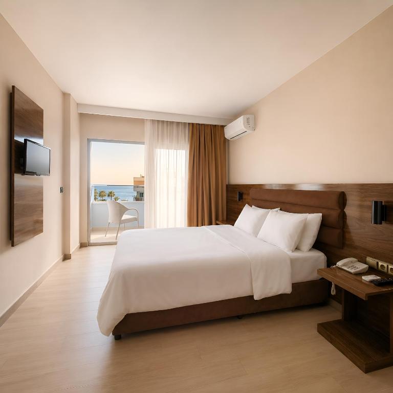 a bedroom with a large bed and a large window at Ozgur Bey Spa Hotel in Alanya