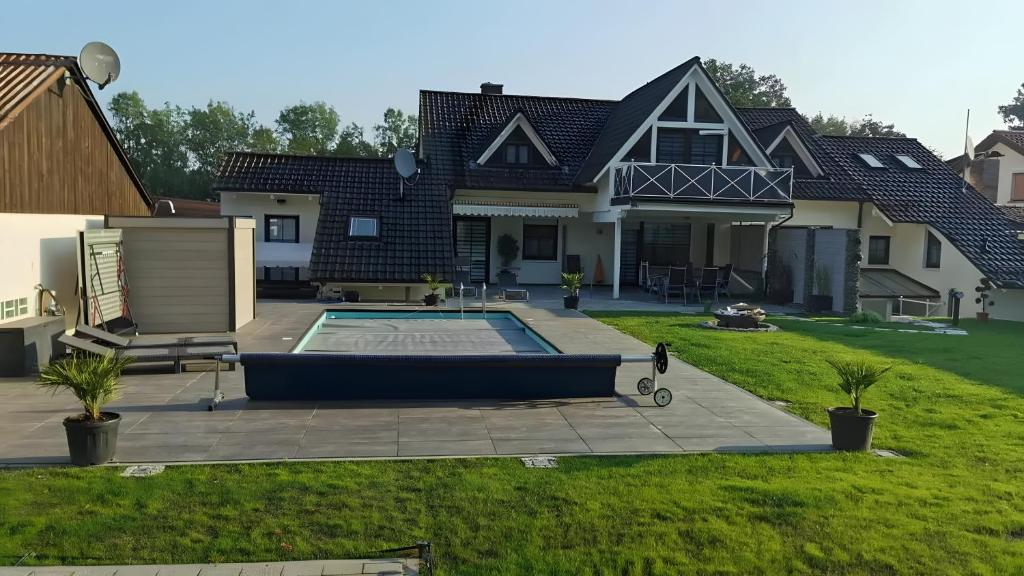 a house with a swimming pool in the yard at Villa-Mainaue in Maineck